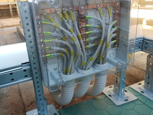 Collettore di terra con barre in rame e cavi etichettati per ogni inverter